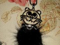 Halskette mit schwarz-haariger Katze auf silberfarbigem Metall