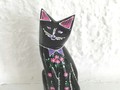 Kleine schwarze Katze mit rosa Blümchen