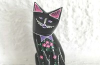 Kleine schwarze Katze mit rosa Blümchen