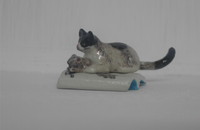 Miniatur Katze mit Maus auf einem Buch liegend